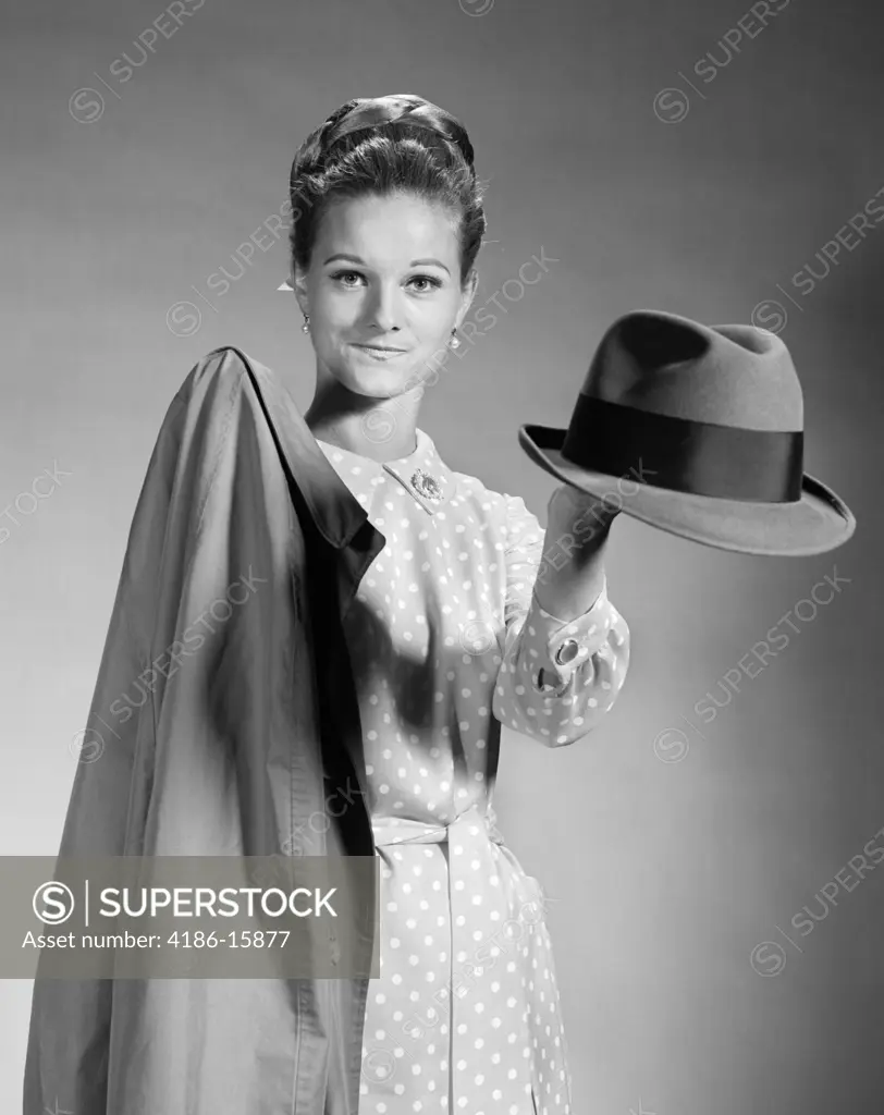 1960S Housewife In Polka-Dotted Dress Holding Out Coat & Hat For Husband