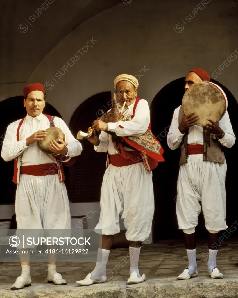 1970s 3 MUSICIANS OF THE ARABIAN PENINSULA PLAYING BAGPIPE OR JIRBA A DRUM OR TABLA GOBLET DRUM AND A DAFF OR FRAME DRUM 