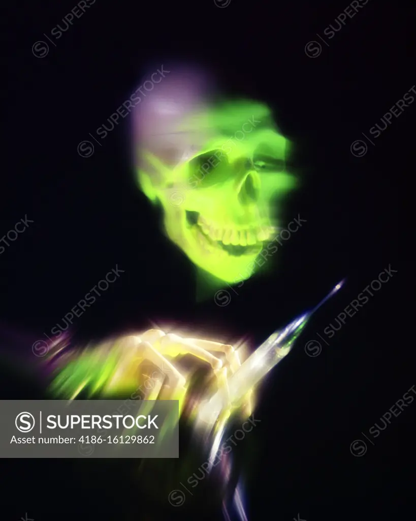 1960s 1970s HUMAN SKULL SKELETON HAND HOLDING HYPODERMIC NEEDLE SYMBOLIC DRUG ABUSE AND ADDICTION PURPLE GREEN LIGHT ON BLACK