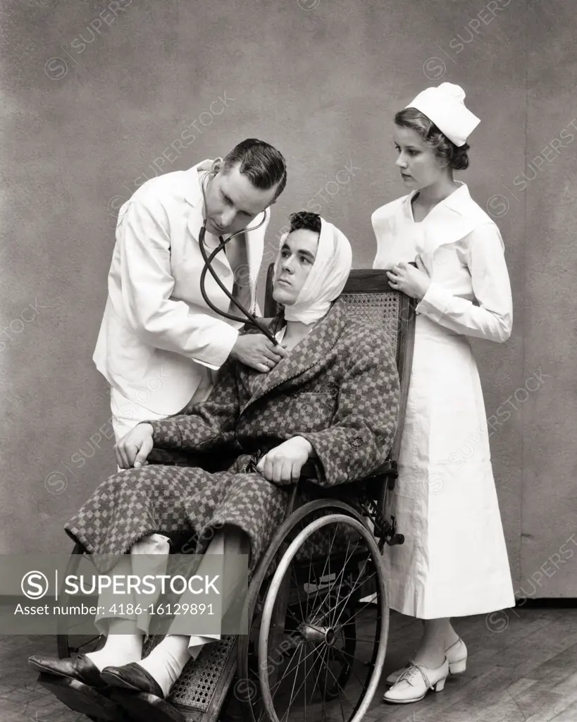 1930s NURSE STANDING BEHIND WHEELCHAIR PATIENT WEARING ROBE AND BANDAGED HEAD AS DOCTOR LISTEN TO HIS HEART WITH STETHOSCOPE 