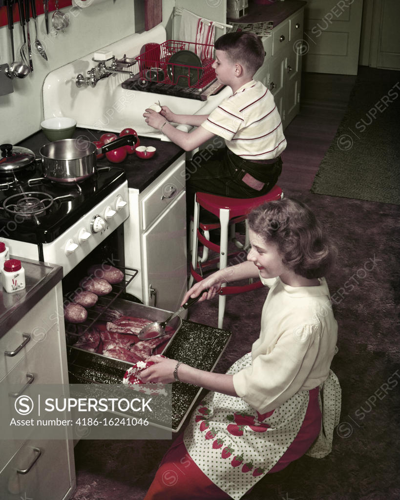 1950s Smiling Boy And Girl Brother And Older Sister Ladling Bread