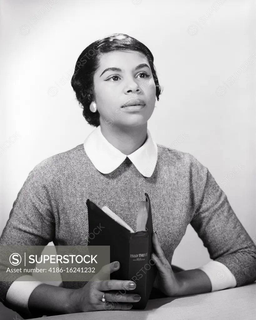 1950s 1960s AFRICAN AMERICAN WOMAN HOLDING BIBLE LOOKING UP PRAYING 