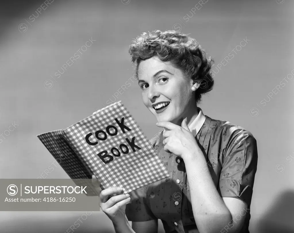 1950S Woman Holding Cookbook Smiling