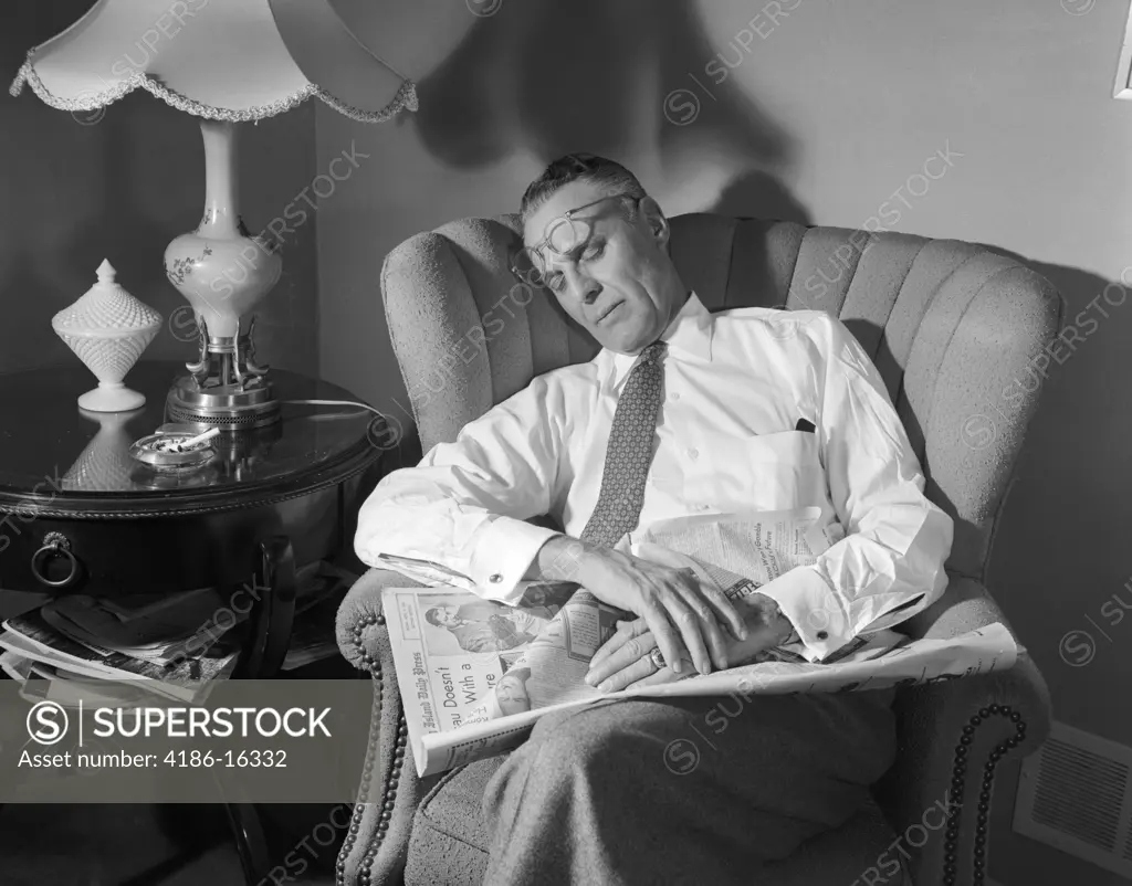 1950S Middle Aged Man Asleep Sleeping In Chair Reading Newspaper Eye Glasses Pushed Up On Forehead