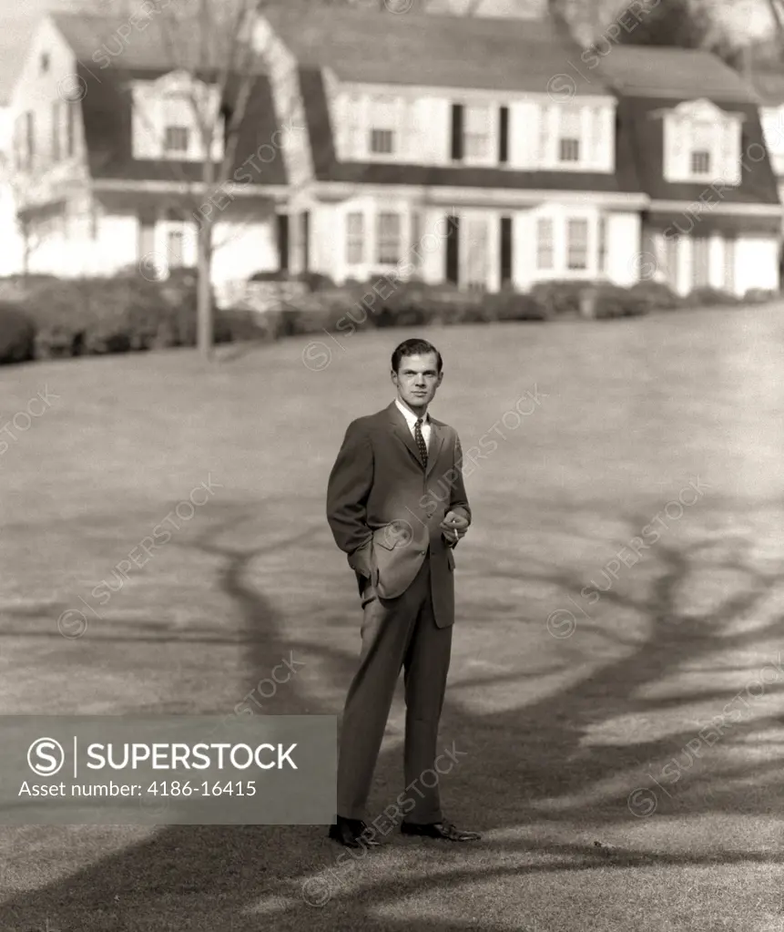 1950S Man Upscale Businessman Executive In Gray Flannel Suit And Tie Standing On Suburban Home Lawn