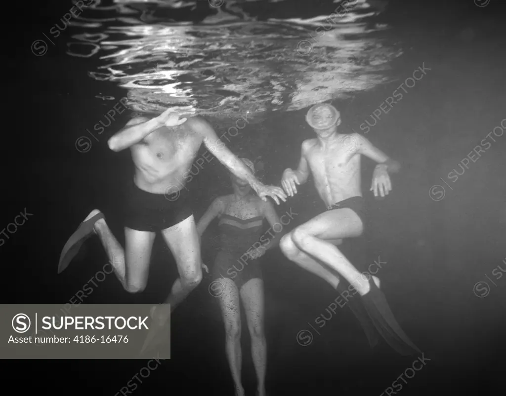 1950S View Of Three Swimmers Under Water