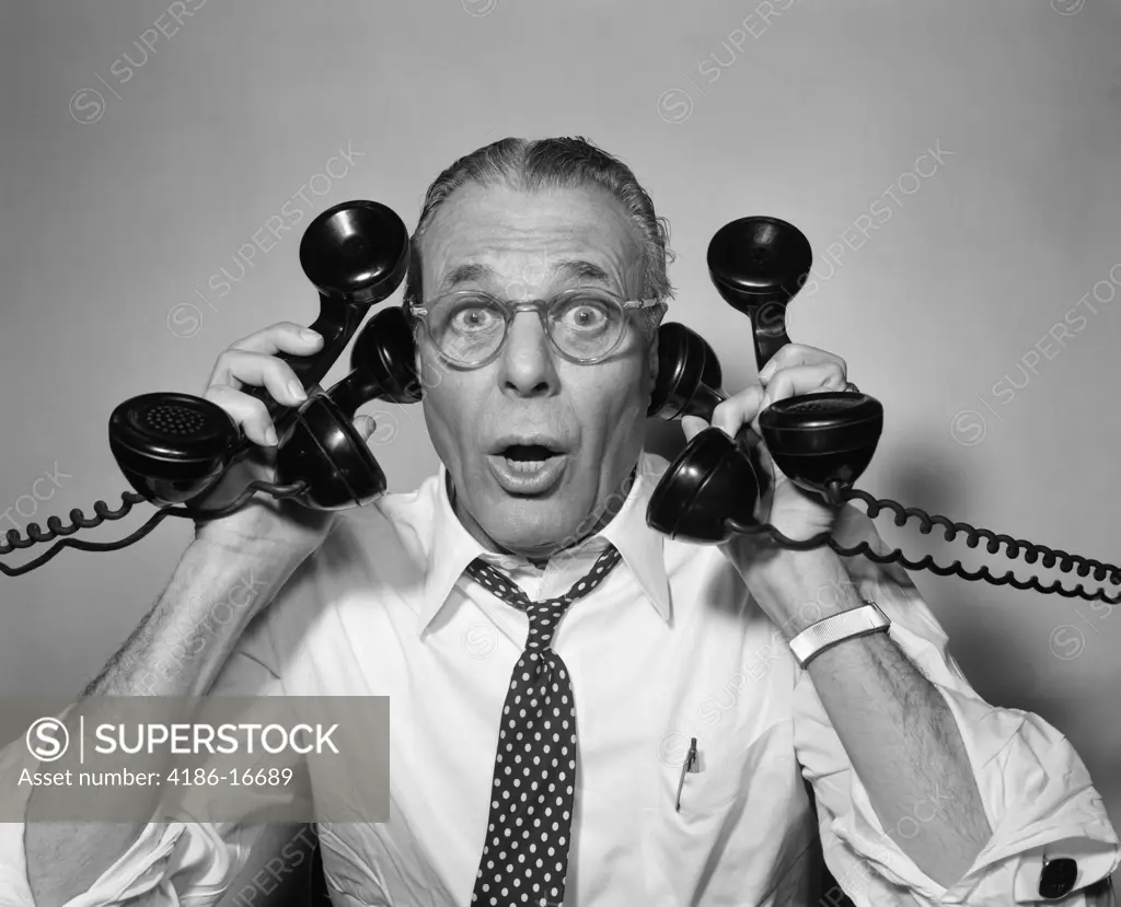 1950S Man With Glasses Holding Four Black Telephones