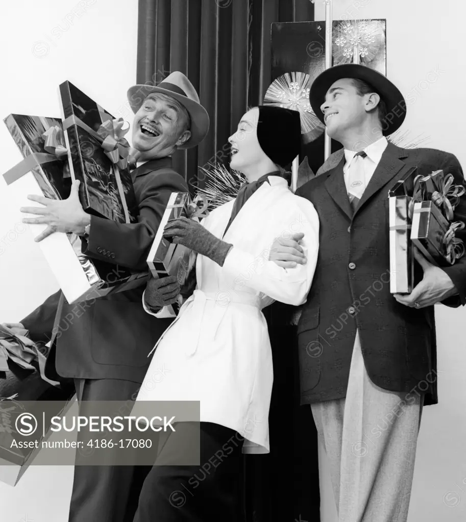 1950S Joyous Laughing Woman And Two Men Carrying Christmas Gifts