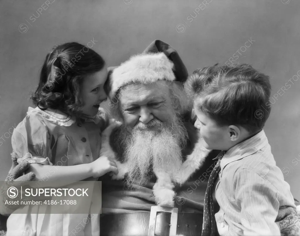 1930S Little Boy With Girl Whispering Telling Santa Claus What She Wants For Christmas