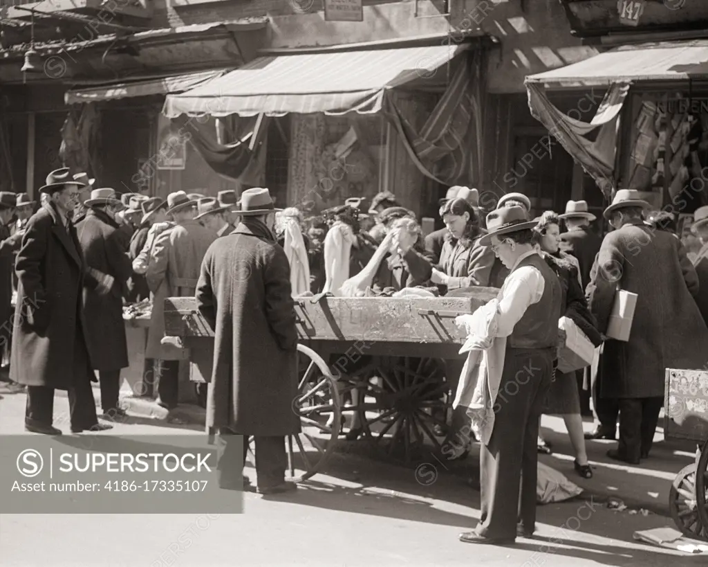 1940s 1950s CROWD OF SHOPPERS MEN WOMEN LOOKING FOR A DEAL AT PUSHCART MARKET ON LOWER EAST SIDE OF MANHATTAN NEW YORK CITY USA