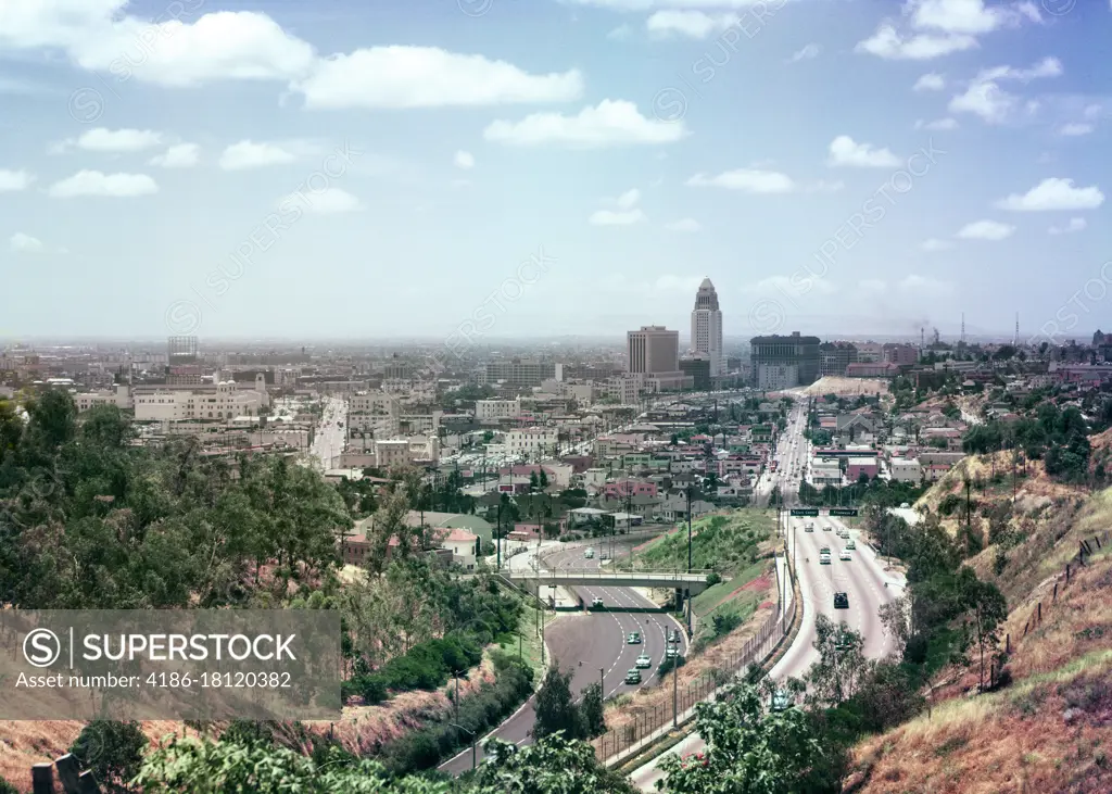 1950s VIEW OF TRAFFIC ON FREEWAY CITY HALL BUILDING DOWNTOWN ON THE HORIZON LOS ANGELES CALIFORNIA USA