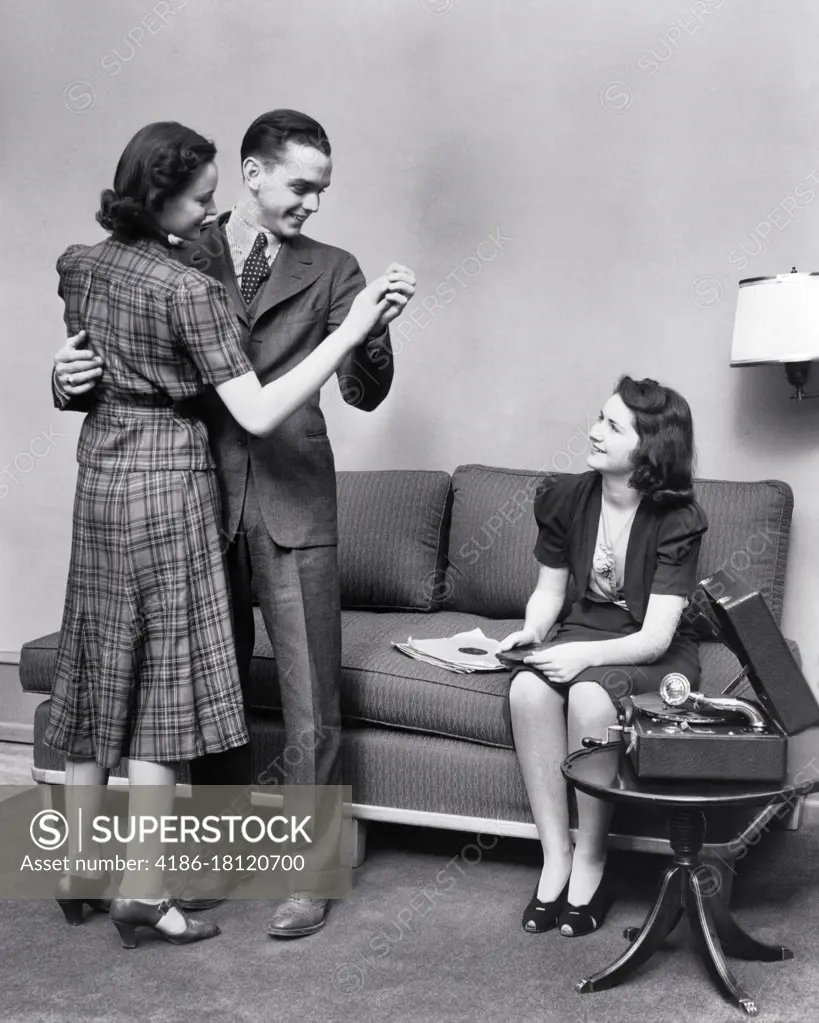 1940s 1930s GROUP OF TEENAGE YOUNG ADULTS IN LIVING ROOM DANCING AND PLAYING 78 RPM RECORDS ON PORTABLE PHOTOGRAPH