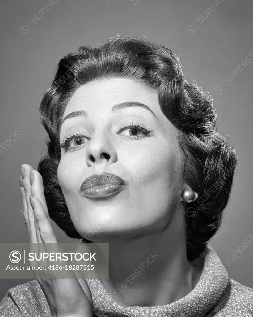 1950s 1960s BRUNETTE WOMAN LOOKING AT CAMERA PUCKERING HER LIPS AS IF TO KISS