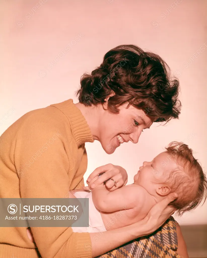 1960s SMILING HAPPY MOTHER HOLDING BABY LAP MOTHERS BABIES PARENT PARENTING FAMILY FAMILIES MOTHERHOOD