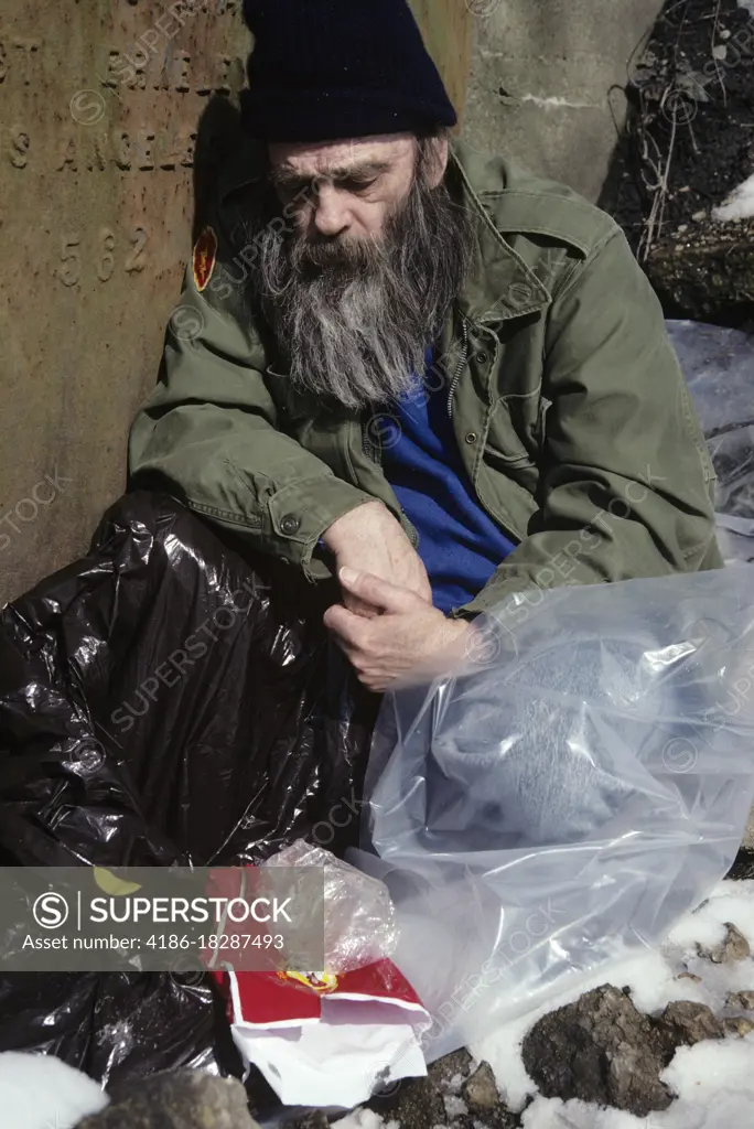 1990s SLEEPING HOMELESS MAN COVERED WITH PLASTIC BAGS 