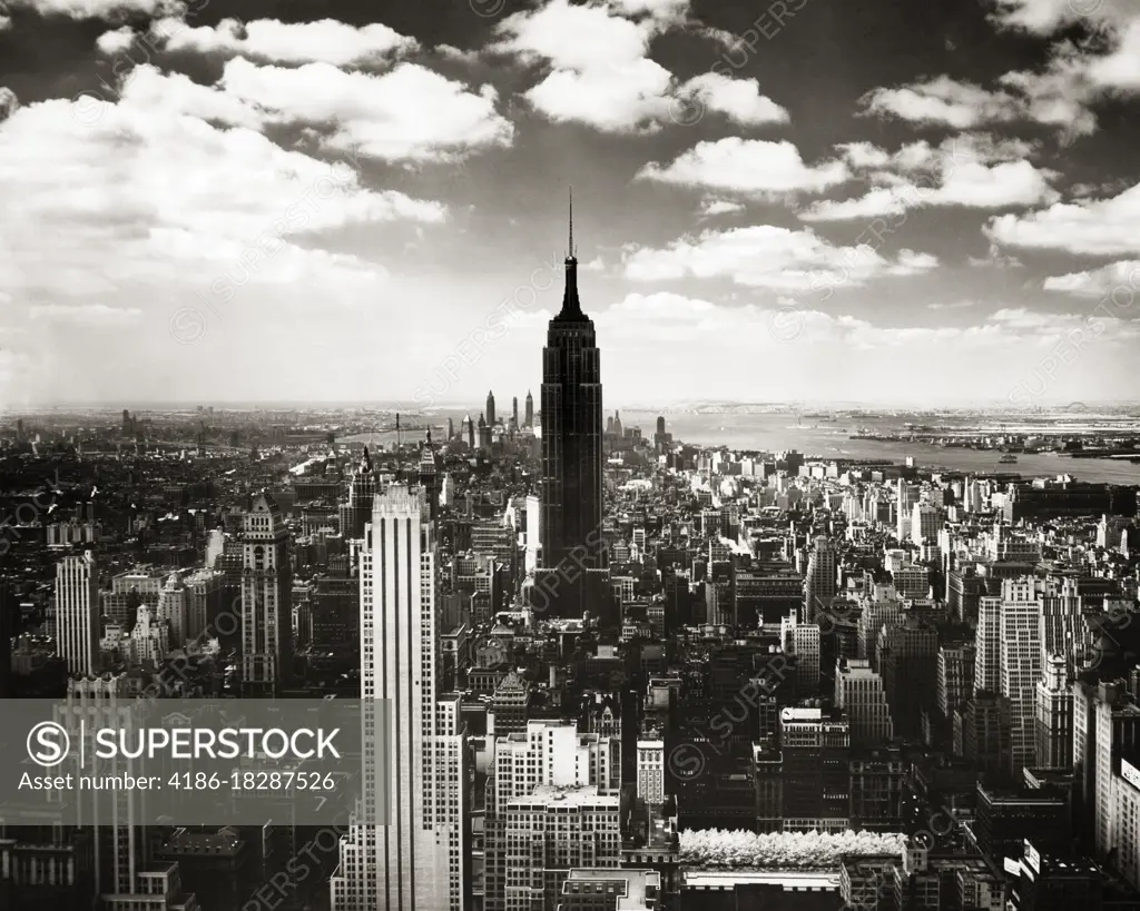 1950s EMPIRE STATE BUILDING SILHOUETTED LOOKING SOUTH FROM THE RCA BUILDING AT ROCKEFELLER CENTER MIDTOWN MANHATTAN NYC USA