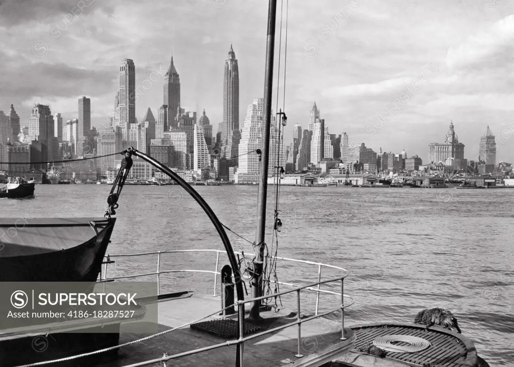 1940s VIEW OF LOWER MANHATTAN ISLAND SKYLINE OF SKYSCRAPER BUILDINGS FROM DECK OF SHIP DOCKED IN BROOKLYN NEW YORK CITY NY USA