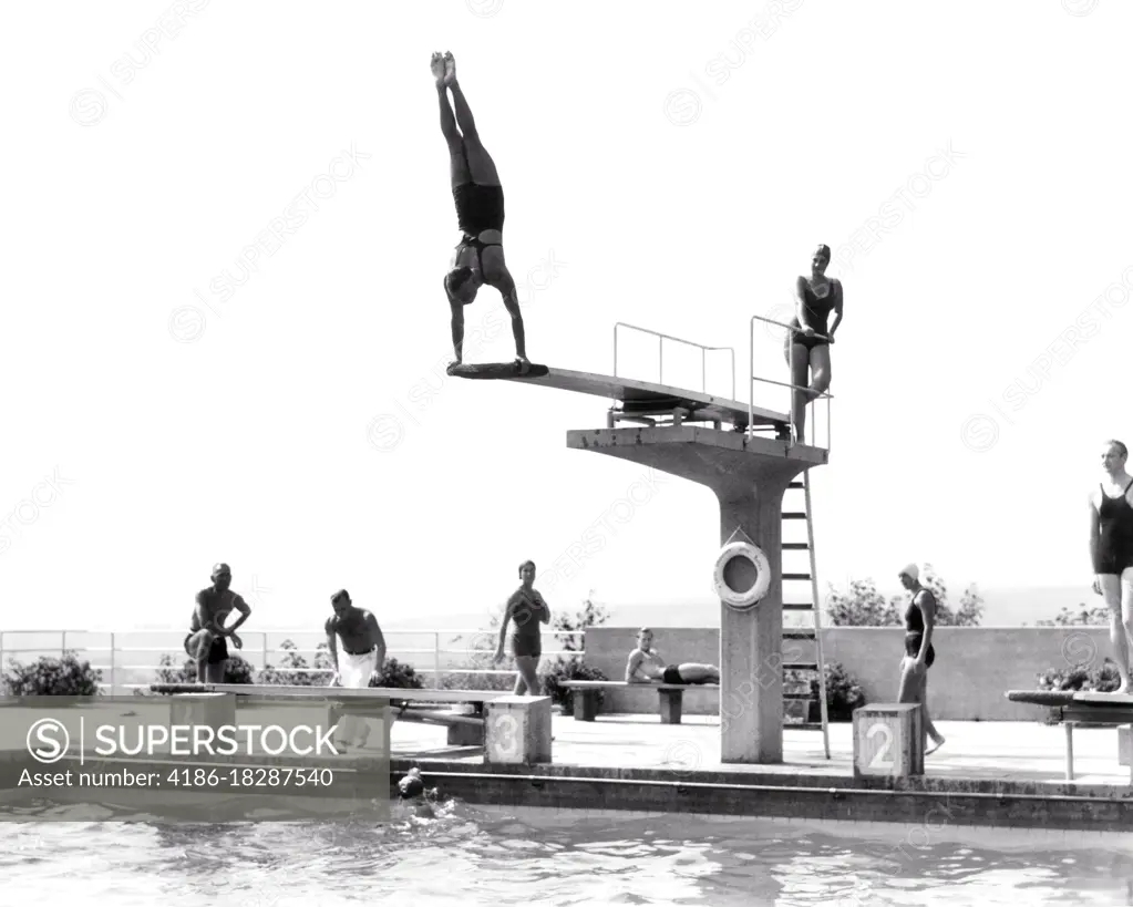 1930s 1935 MAN DOING HANDSTAND ON DIVING BOARD SWIMMING POOL THE OPELBAD IN NEROBERG HILL OVERLOOKING WIESBADEN GERMANY