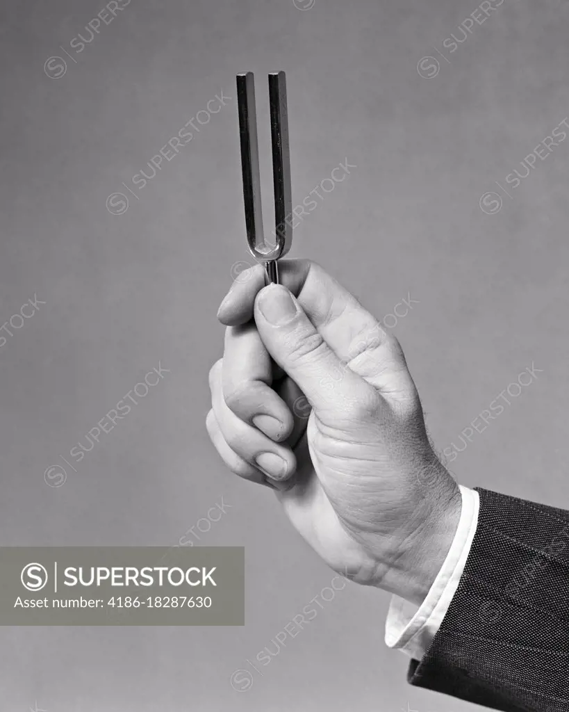 1940s MALE HAND HOLDING A TUNING FORK