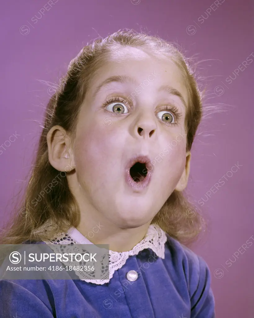 1960s LITTLE GIRL MAKING FUNNY FACE EXPRESSION OF SURPRISE WONDER AWE SHOCK EYES AND MOUTH WIDE OPEN