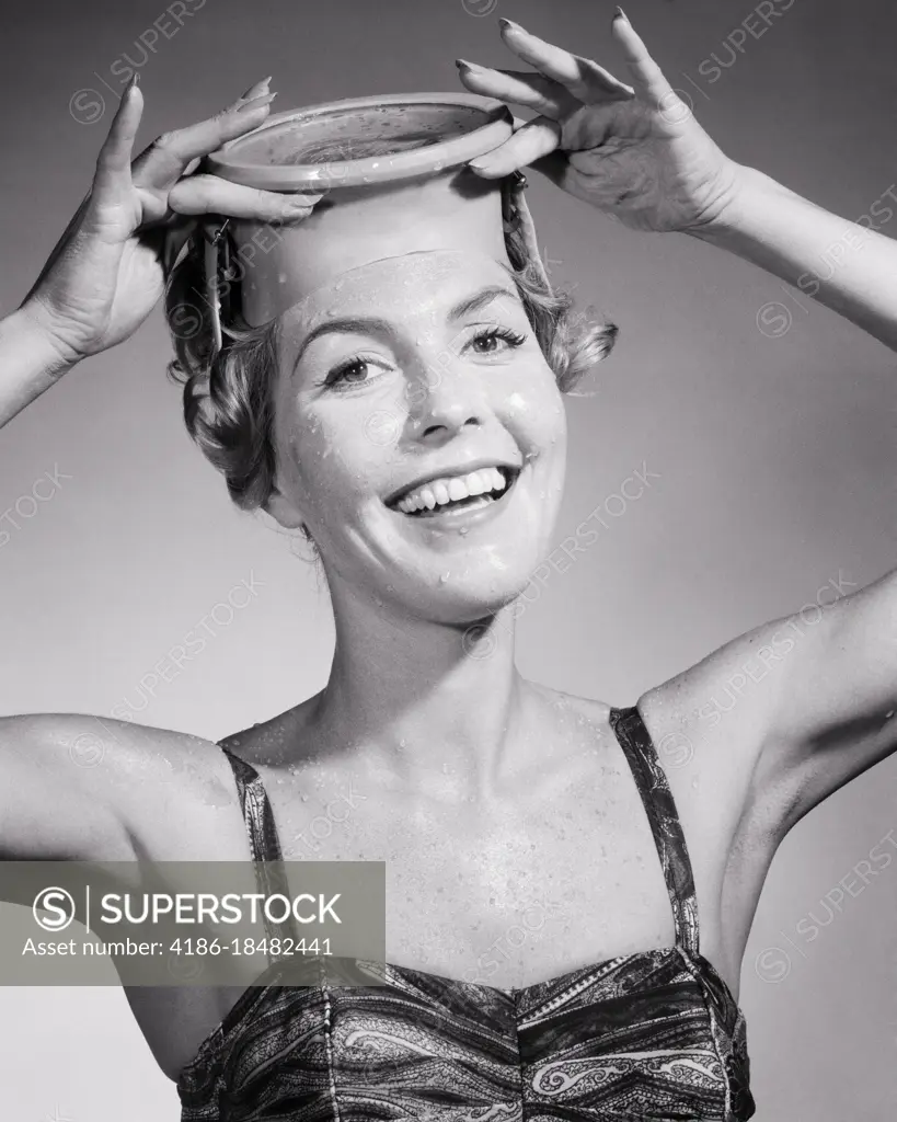 1950s SMILING WOMAN LOOKING AT CAMERA WEARING BATHING SUIT PUTTING ON SCUBA DIVING MASK 