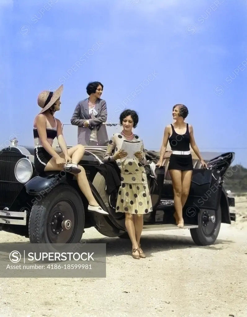 1920s 1930s FOUR WOMEN IN DRESSES AND BATHING SUITS GATHERED AROUND CONVERTIBLE TOURING CAR AT SEASHORE BEACH