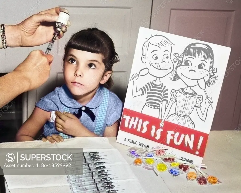 1950s LITTLE GIRL LOOKING UP ABOUT TO GET POLIO VACCINATION AT SCHOOL SIGN THIS IS FUN WITH LOLLIPOPS