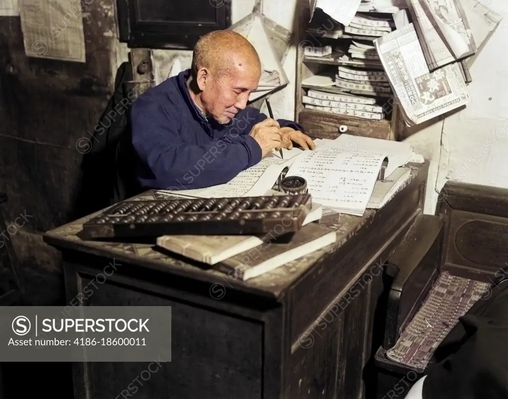 1920s 1930s CHINESE MAN WRITING LEDGER USING ABACUS BOOKKEEPER ACCOUNTANT WORKER ACCOUNTING OFFICE SCRIBE HONG KONG CHINA