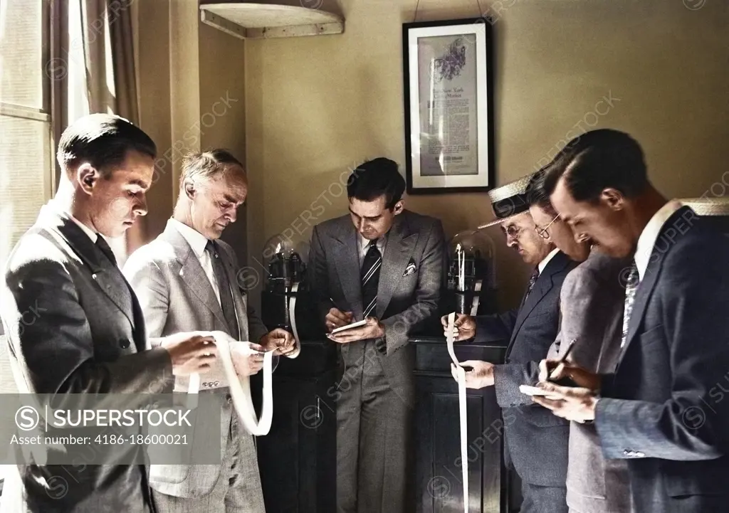 1920s 1930s SIX MEN INVESTORS AND STOCK BROKERS READING PAPER TICKER TAPE INVENTED IN 1867 BY EDWARD CALAHAN NEW YORK CITY USA