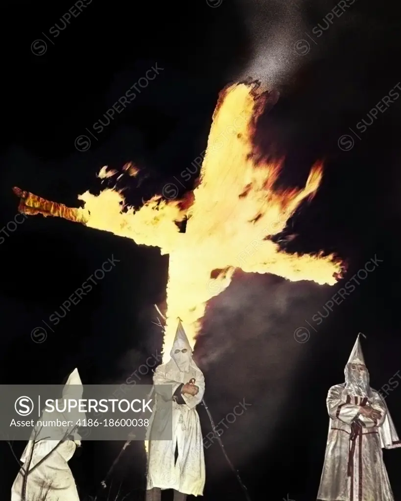 1930s HOODED MEMBERS OF KKK KU KLUX KLAN STANDING IN FRONT OF BURNING CROSS