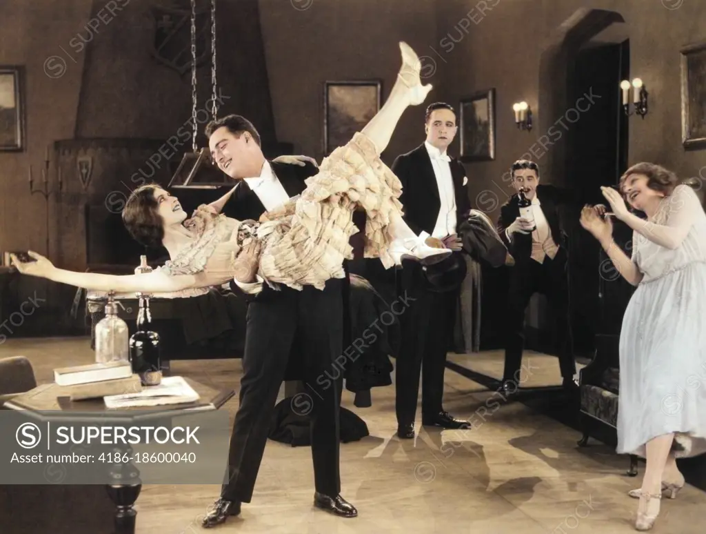 1920s WILD PARTY WITH WOMAN FLAPPER TURNED UPSIDE-DOWN IN ARMS OF MAN DANCING SILENT MOVIE STILL