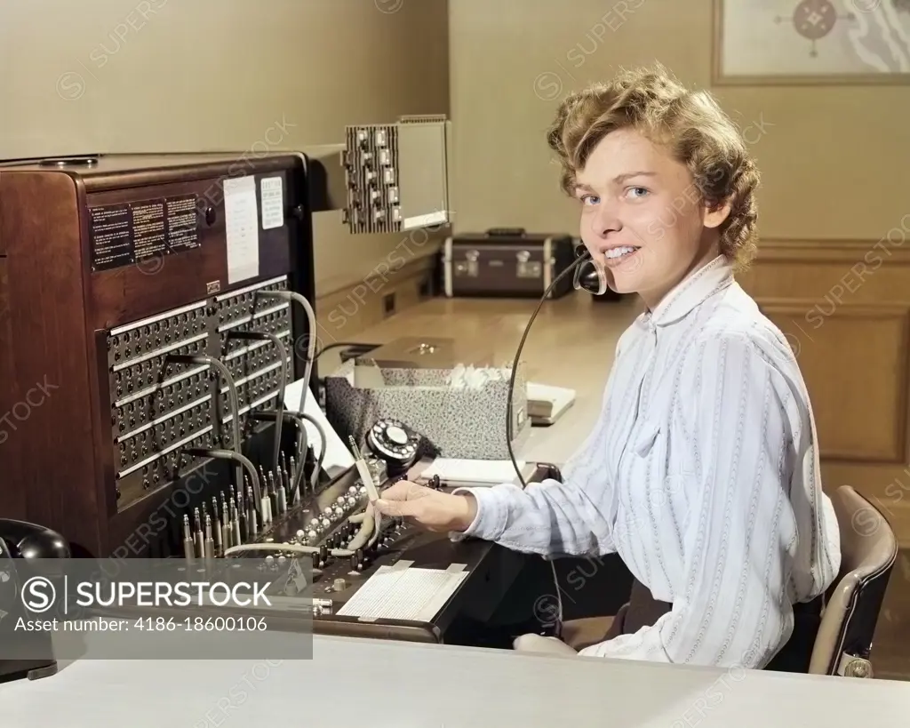 1950s SMILING WOMAN OFFICE TELEPHONE SWITCHBOARD OPERATOR RECEPTIONIST LOOKING AT CAMERA