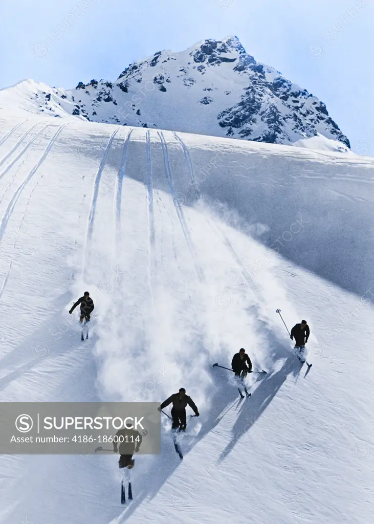 1920s 1930s FIVE ANONYMOUS MEN SKIING DOWN SNOW COVERED ALPS SWITZERLAND