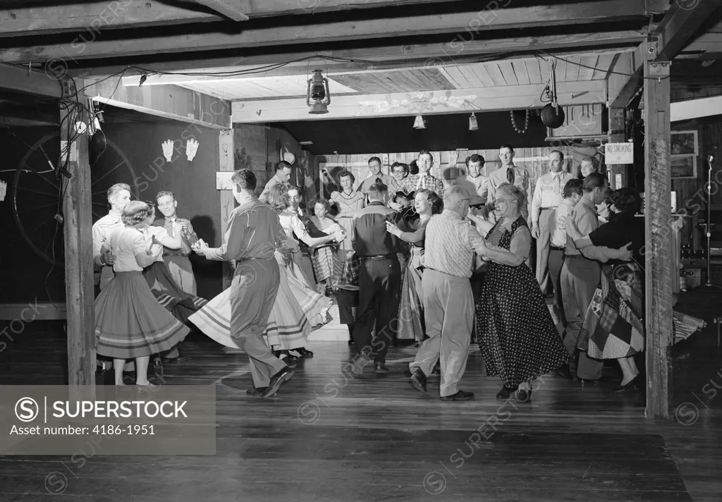 1950S Square Dancers In Country Western Outfits Dancing To Music Of A Small Band In A Barn