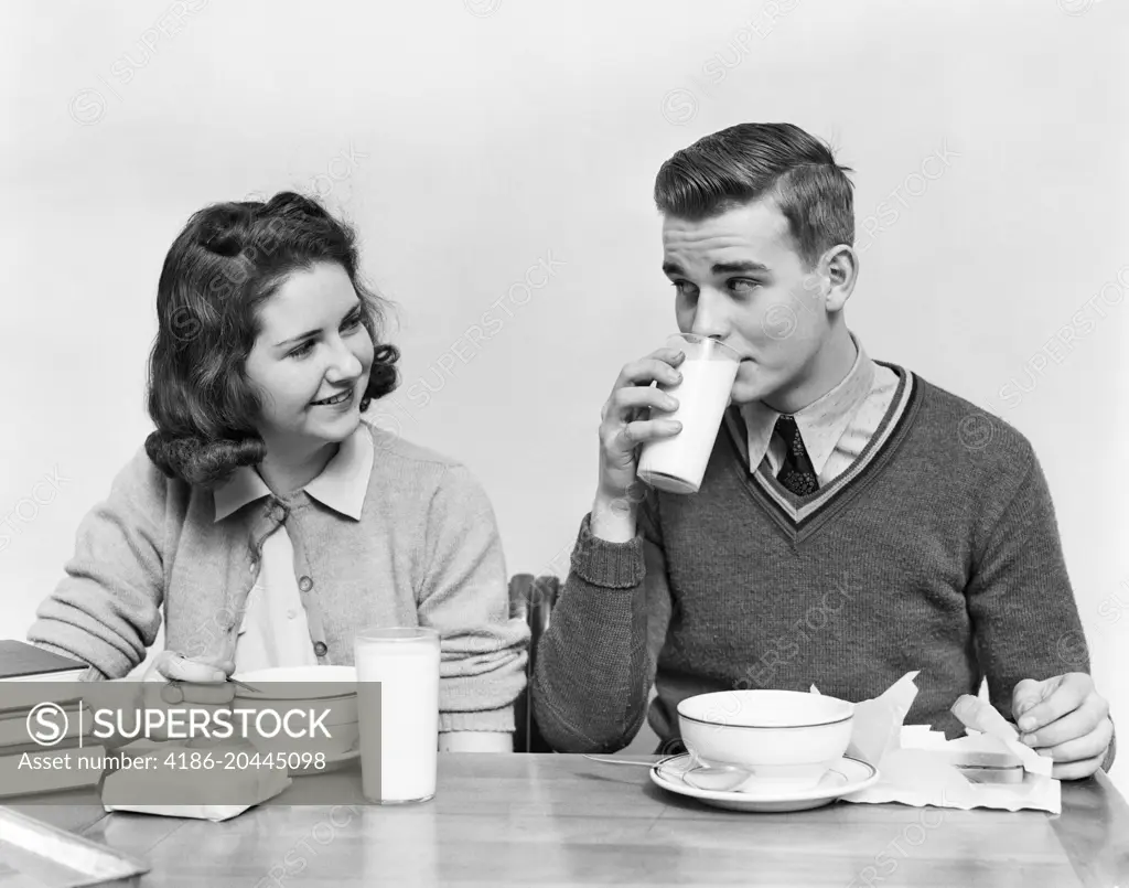 1940s TEENAGE GIRL AND BOY EATING SCHOOL    LUNCH SOUP SANDWICHES TOGETHER BOY DRINKING MILK