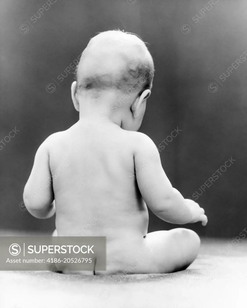 1930s NUDE NAKED BABY VIEWED FROM REAR SITTING ON BARE BOTTOM BEHIND -  SuperStock