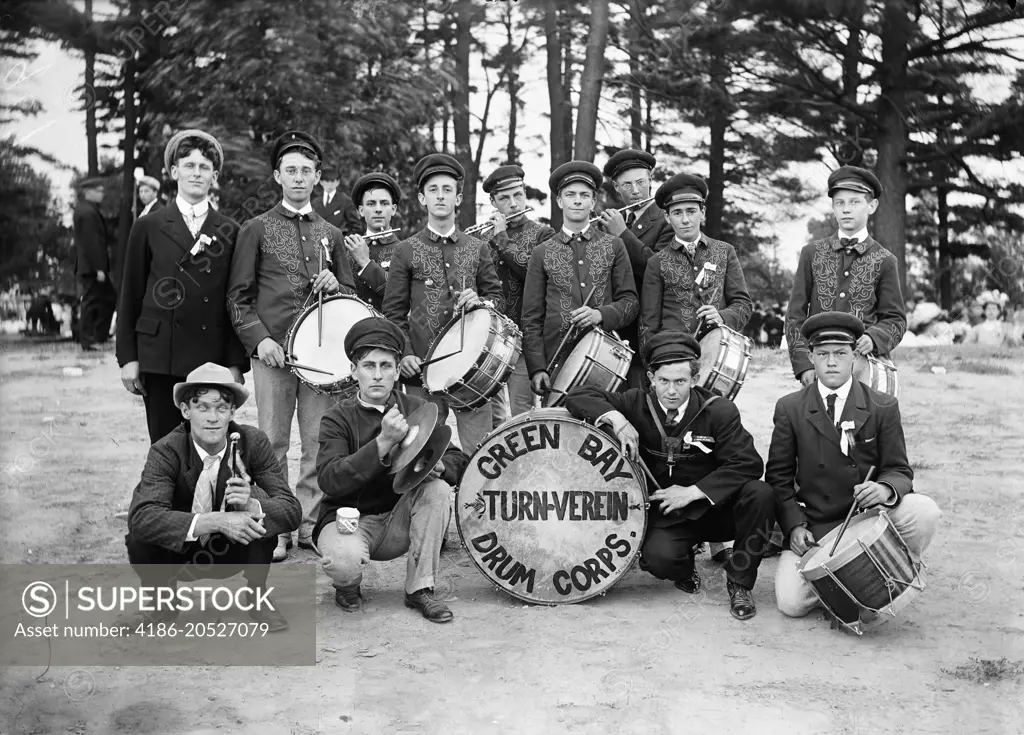 OUTDOOR GROUP PORTRAIT OF TURN OF THE CENTURY DRUM CORPS FLUTISTS IN BACK ROW