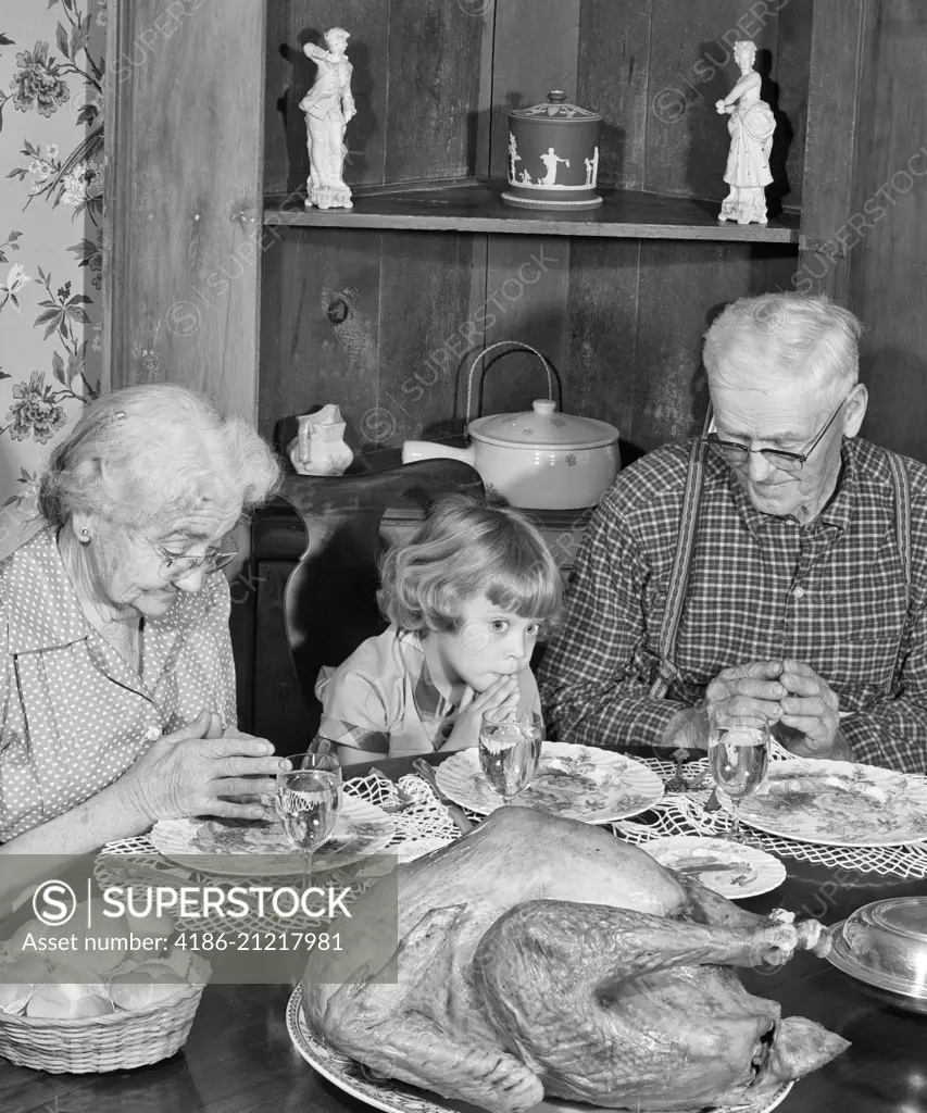 1950s FAMILY THANKSGIVING DINNER PRAYING GIRL AND GRANDPARENTS