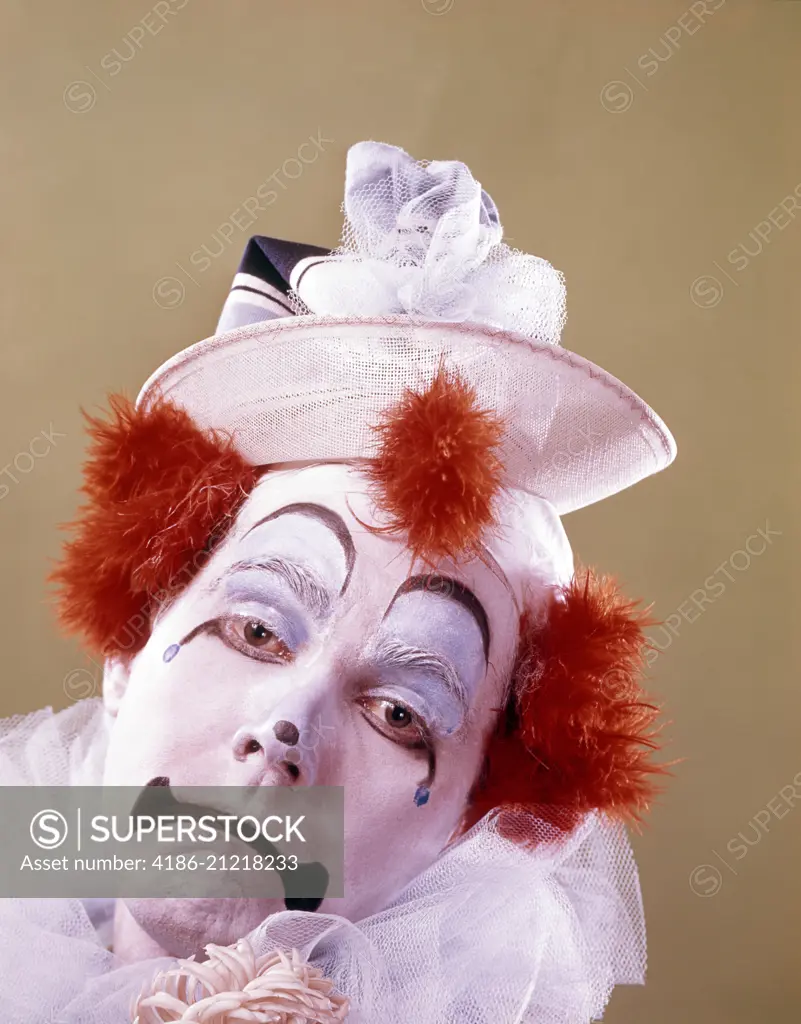 1970s PORTRAIT OF A SAD CLOWN BRIGHT ORANGE HAIR TUFTS LOOKING AT CAMERA 