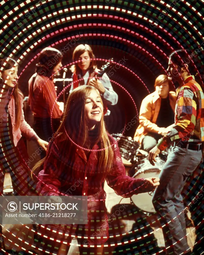 1970s TEENAGE ROCK BAND GROUP AND BOYS AND GIRLS DISCO DANCING AMID SWIRLING PSYCHEDELIC LIGHTS AND MUSIC