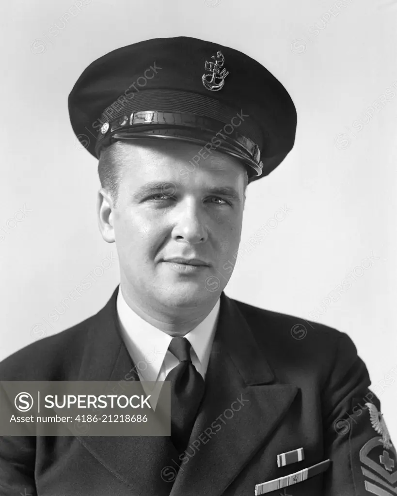 1940s PORTRAIT MAN VETERAN NAVY CHIEF PETTY OFFICER IN UNIFORM AND HAT LOOKING AT CAMERA