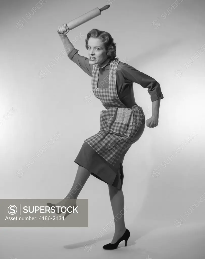 1950S Angry Housewife In Apron Wielding Rolling Pin Over Her Head