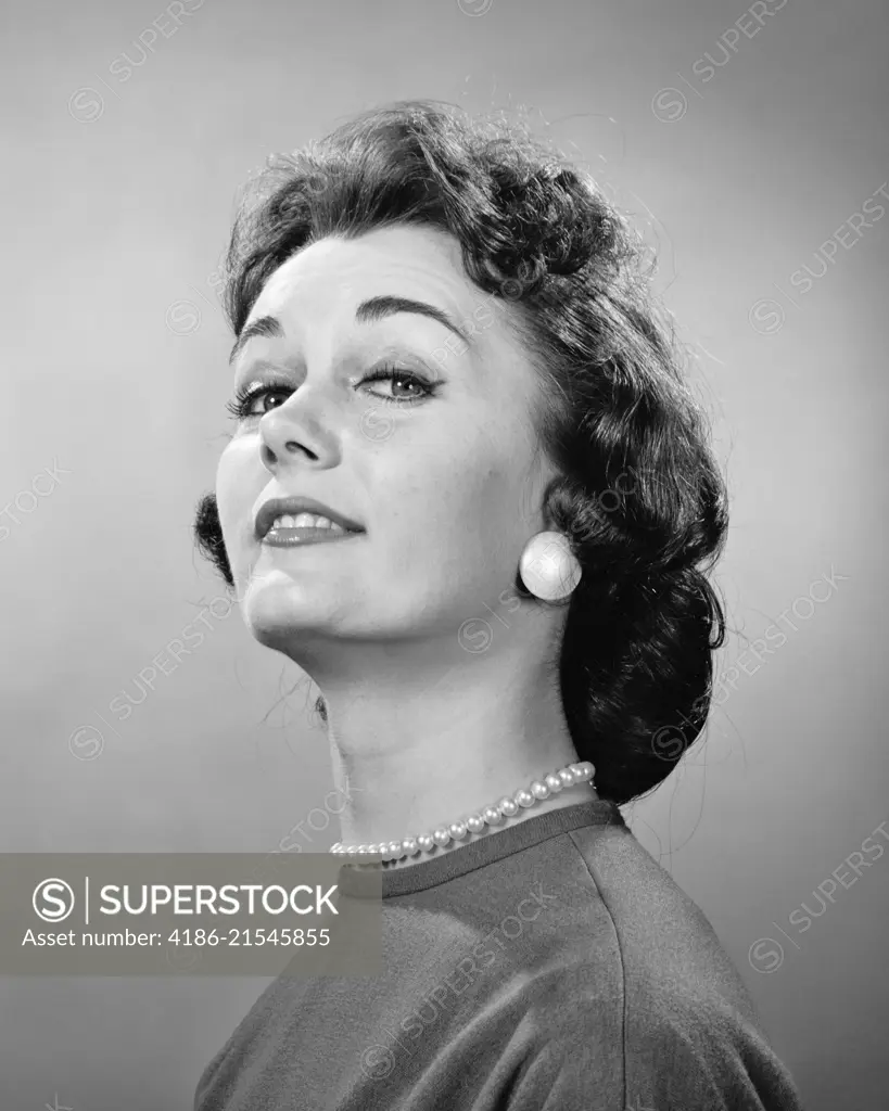 1950s 1960s BRUNETTE WOMAN CHIN UP SUPERIOR THOUGHTFUL FACIAL EXPRESSION LOOKING AT CAMERA