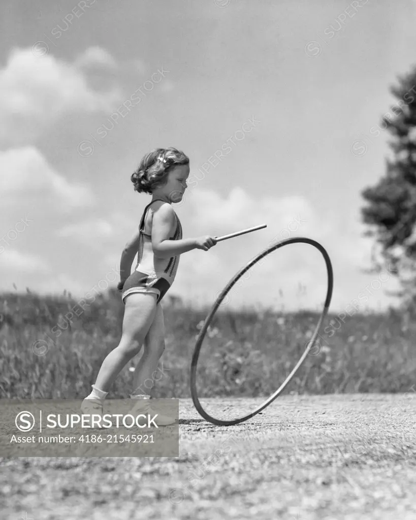 1930s GIRL OUTDOORS ROLLING A HOOP PLAYING HOOP AND STICK GAME 