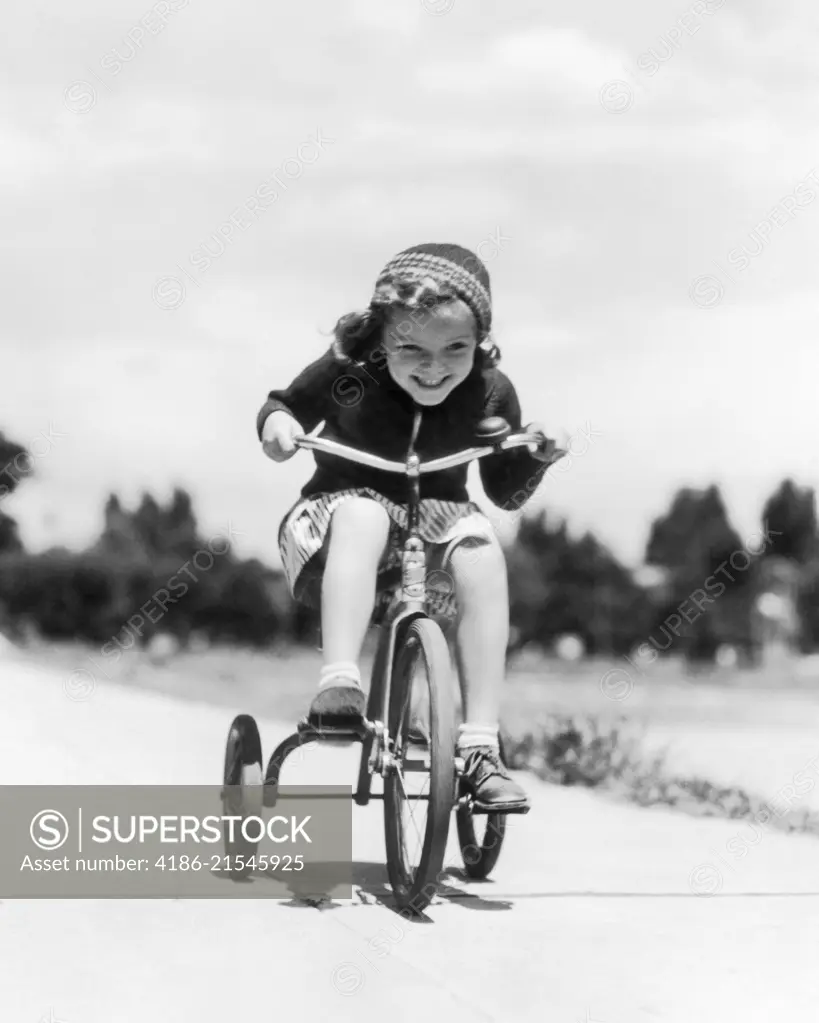 1930s 1940s GIRL RIDING TRICYCLE ON SIDEWALK