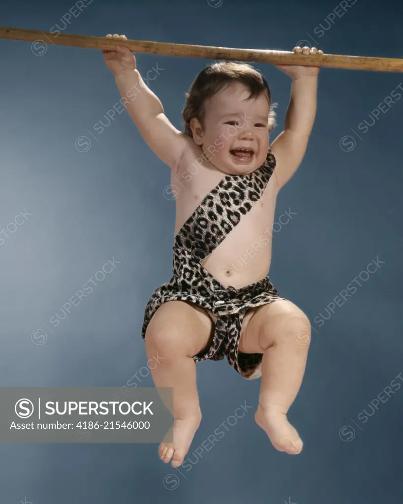 1960S CRYING BABY IN LEOPARD SKIN TARZAN SUIT SWINGING FROM A BRANCH