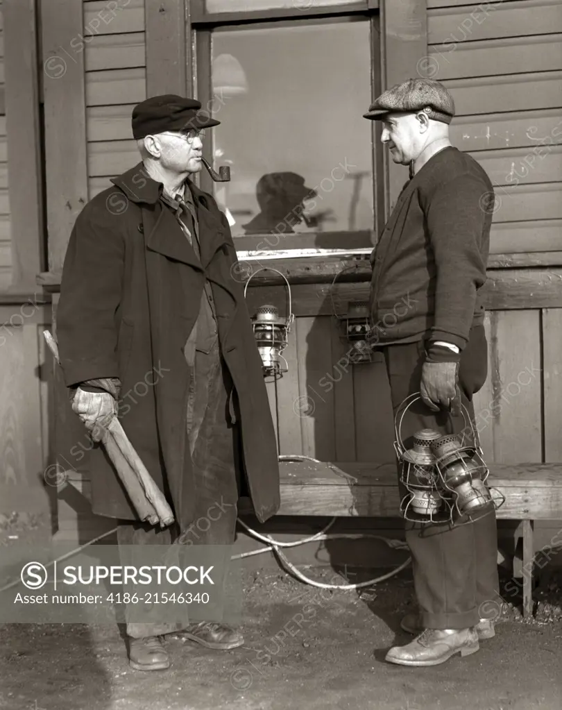 1920s 1930s TWO RAILROAD WORKERS HOLDING LANTERNS & FLAGS A FLAGMAN CONDUCTOR AND A BRAKEMAN MEETING AND TALKING