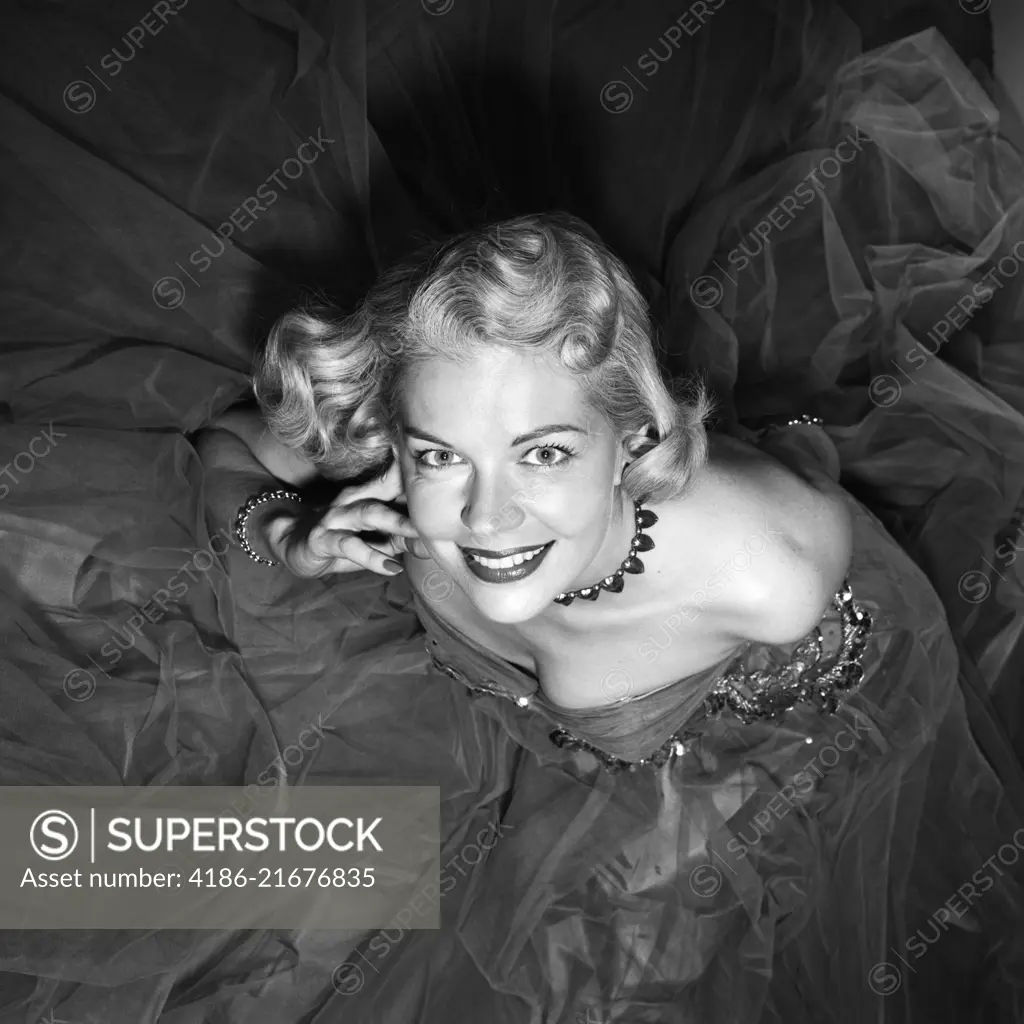 1950s SMILING BLOND WOMAN LOOKING UP FORMAL STRAPLESS EVENING GOWN GLAMOROUS 