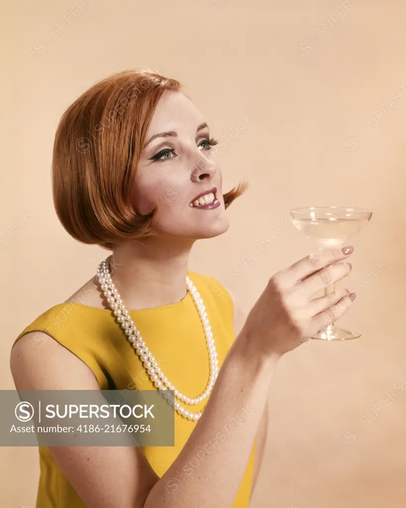 1960s FASHIONABLE RED HEADED WOMAN TOASTING HOLDING GLASS OF CHAMPAGNE 