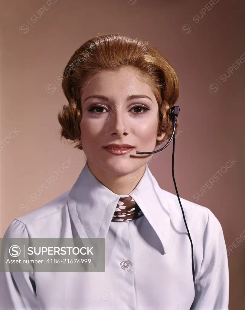 1960s 1970s PORTRAIT SERIOUS WOMAN TELEPHONE OPERATOR WEARING HEADSET MICROPHONE LOOKING AT CAMERA